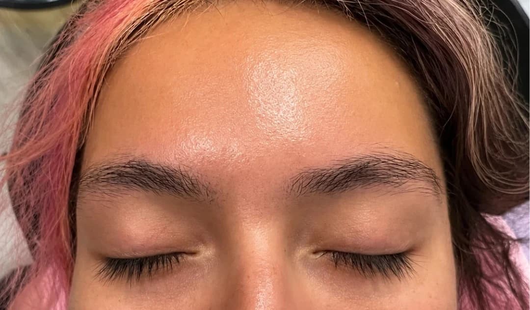 A client's brows before threading — unshaped, with stray hairs